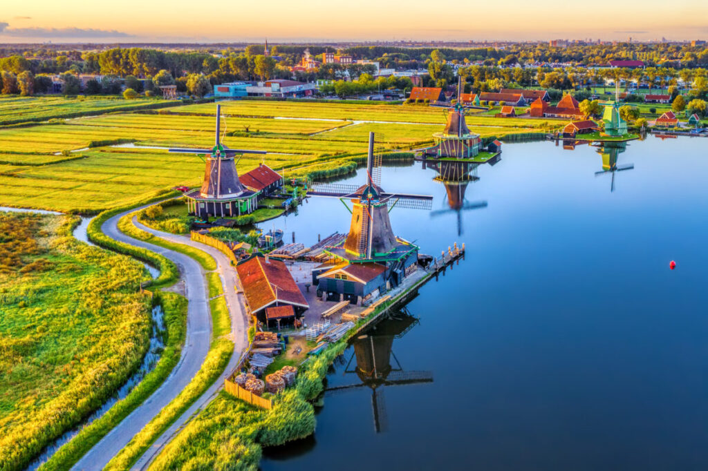 Kinderdijk vs Zaanse Schans Windmills: Which Dutch Icon Wins? 11 Aerial view of Zaanse Schans, showcasing iconic windmills and lush green fields in North Holland, Netherlands.