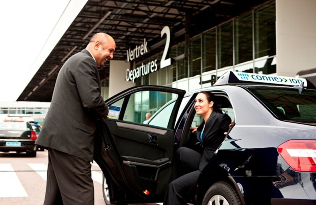 Amsterdam Airport Train vs Taxi: Which Is Better in 2026? 13 Travelers entering an official taxi at Amsterdam Airport Schiphol