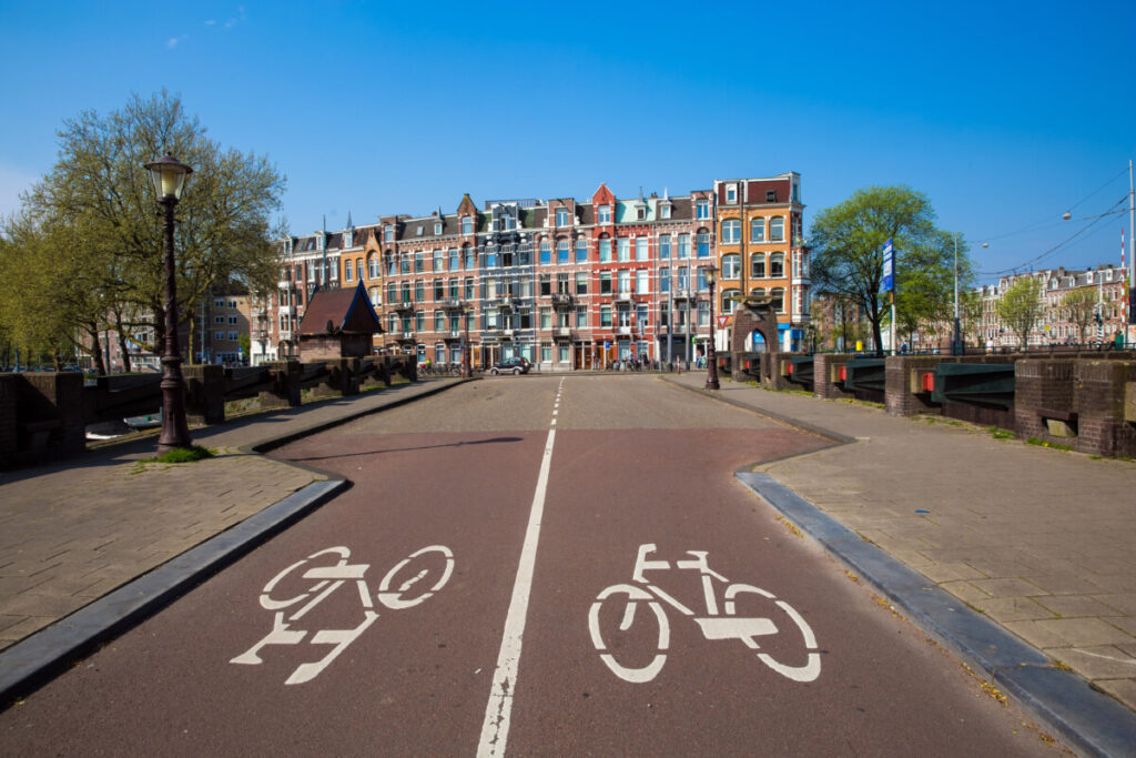 Navigate Amsterdam Like a Pro: 6 Transport Blunders to Avoid 5 Panoramic view of bike lane sign and houses in Amsterdam , Netherlands