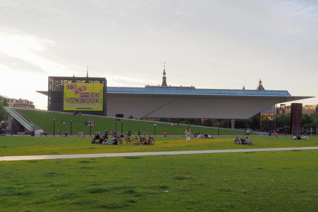 20 Insider Secrets for Exploring Amsterdam on a Shoestring: Your Ultimate Budget-Friendly Guide 17 Dusk view of Stedelijk Museum with visitors on Museumplein lawn, Amsterdam
