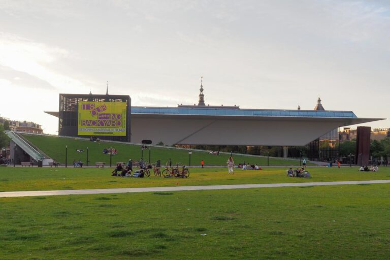 Dusk view of Stedelijk Museum with visitors on Museumplein lawn, Amsterdam