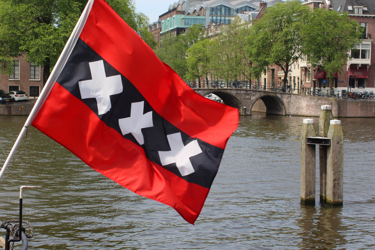 Flag of Amsterdam: 3 Striking Symbols Unveiled 1 Close-up of the Amsterdam flag by the canal