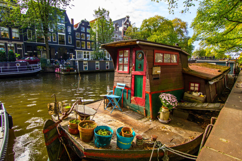 Amsterdam's Floating World: Life on the City's Houseboats 6 Close-up of a houseboat door and plants in a canal in Amsterdam, Netherlands