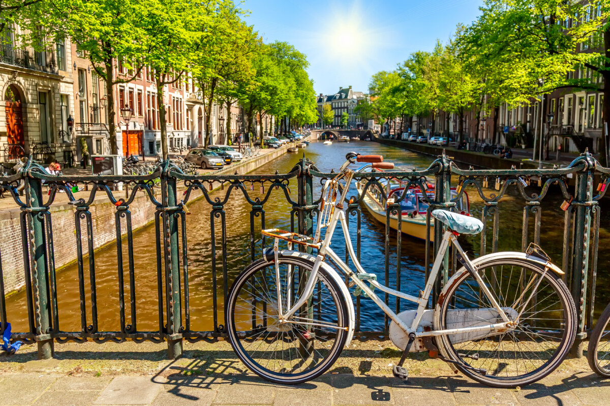 5 Essential Amsterdam Bike Rental Tips & Scenic Routes: Unlock the City Like a Local 1 Bicycle leaning against a bridge overlooking a canal in Amsterdam, Netherlands