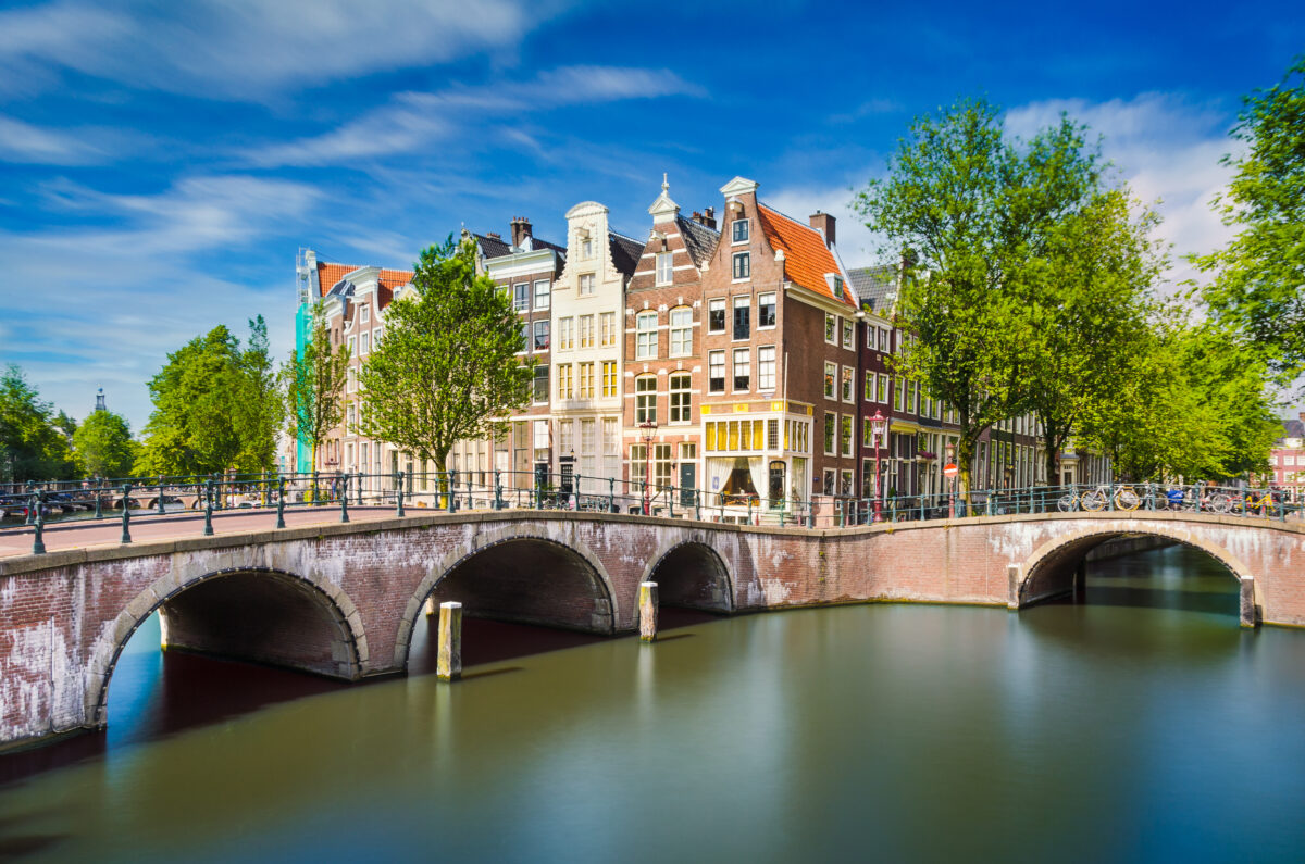 How to Visit Amsterdam on a Tight Budget (2026) 1 Picturesque Amsterdam canal surrounded by historic buildings, showcasing the city's iconic architecture and charm