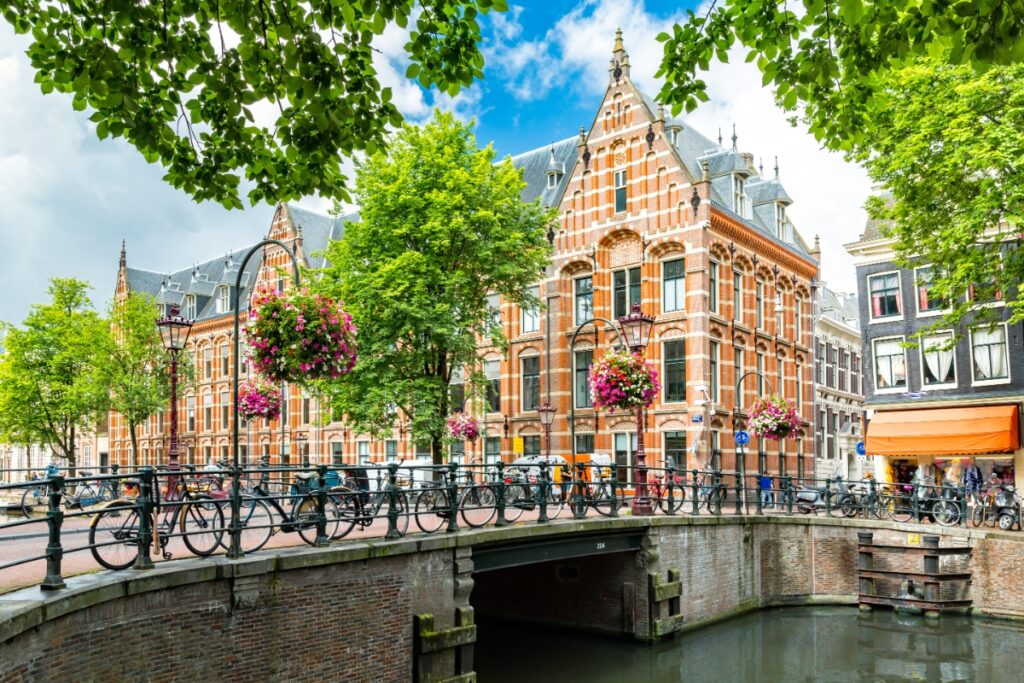 20 Insider Secrets for Exploring Amsterdam on a Shoestring: Your Ultimate Budget-Friendly Guide 18 Canal-side with parked bicycles, houses, and plants in Amsterdam, Netherlands