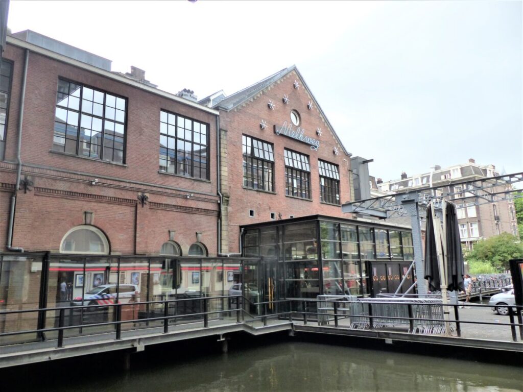 Where to Stay for Amsterdam Dance Event: 2026’s Top Areas & Insider Tips 6 Exterior view of the Melkweg building in Amsterdam featuring a prominent large window.