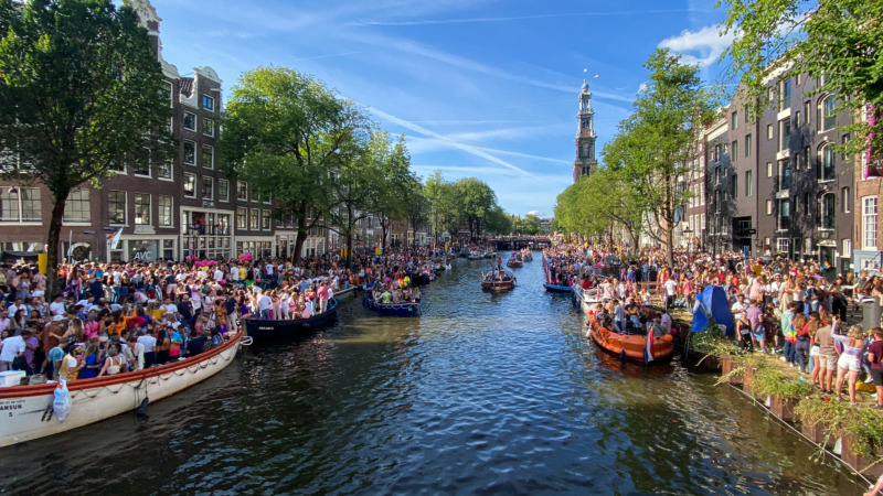 The Evolution of Tourism in the Netherlands: 24 Surprising Insights 4 Tourists and locals celebrating Amsterdam Pride in August in Amsterdam, Netherlands