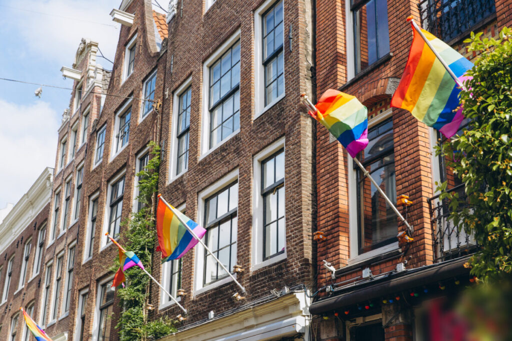 Amsterdam Pride 2026: Your Guide to the Canal Parade & Saturday Party Day 3 Rainbow flag displayed on a building in Amsterdam, symbolizing support for the LGBT community during Pride celebrations.