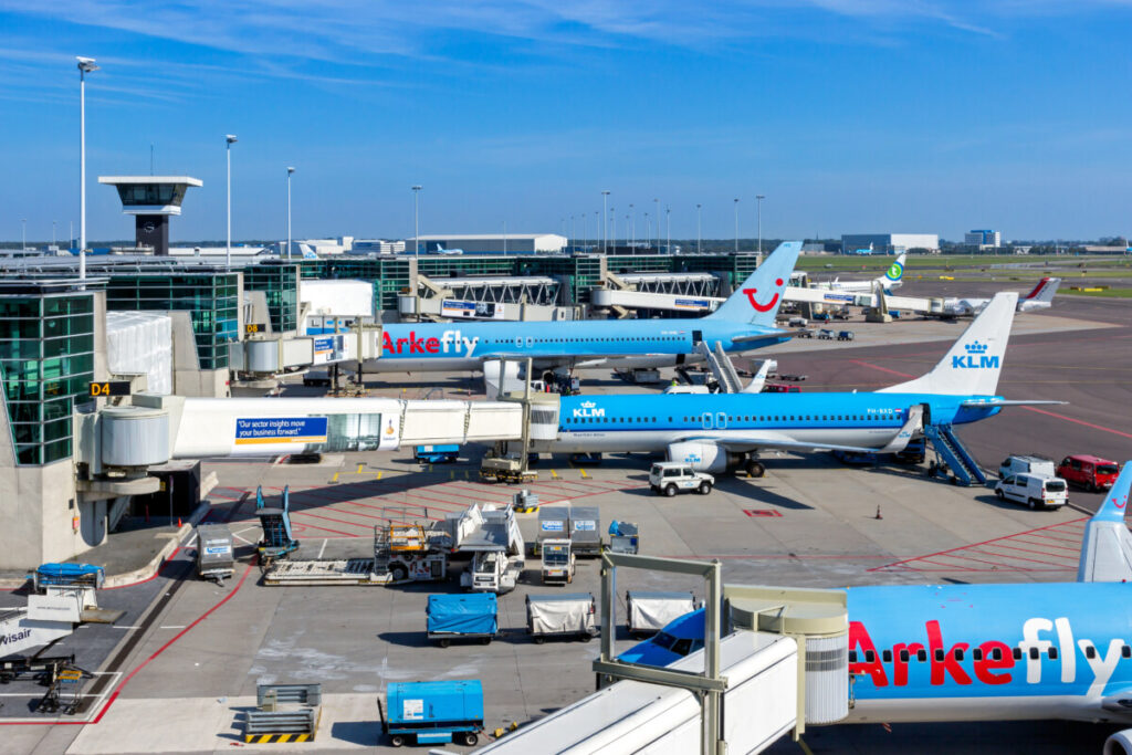 Amsterdam Airport Train vs Taxi: Which Is Better in 2026? 25 KLM and ArkeFly passenger planes at Schiphol Airport in Amsterdam, Netherlands