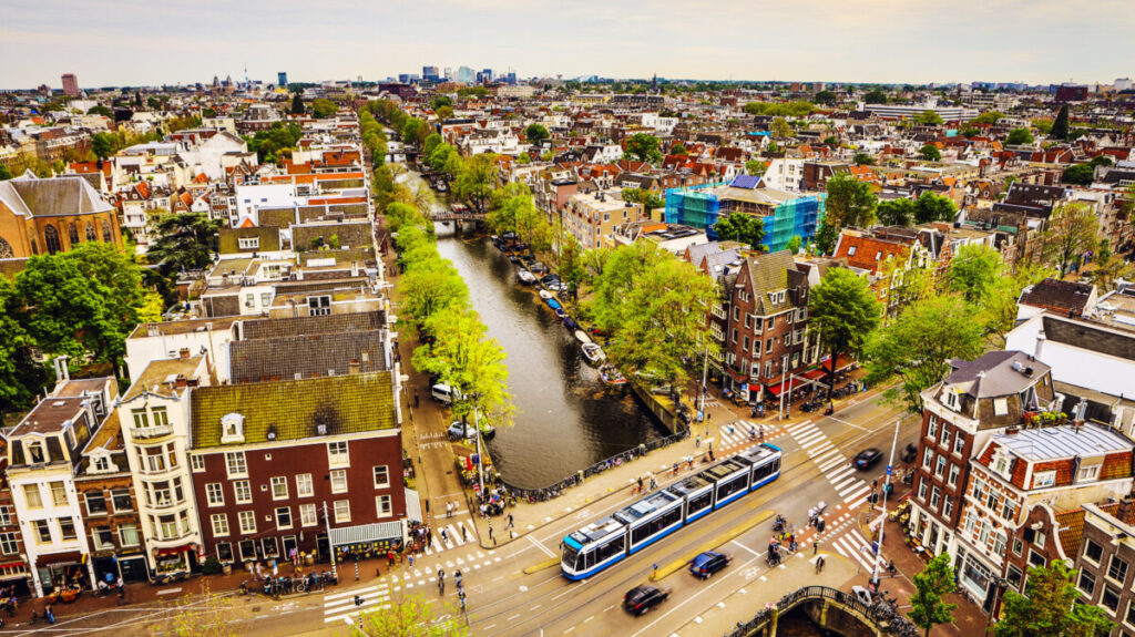 20 Insider Secrets for Exploring Amsterdam on a Shoestring: Your Ultimate Budget-Friendly Guide 13 Panoramic view of Amsterdam showcasing a tram and the vibrant cityscape under a clear blue sky
