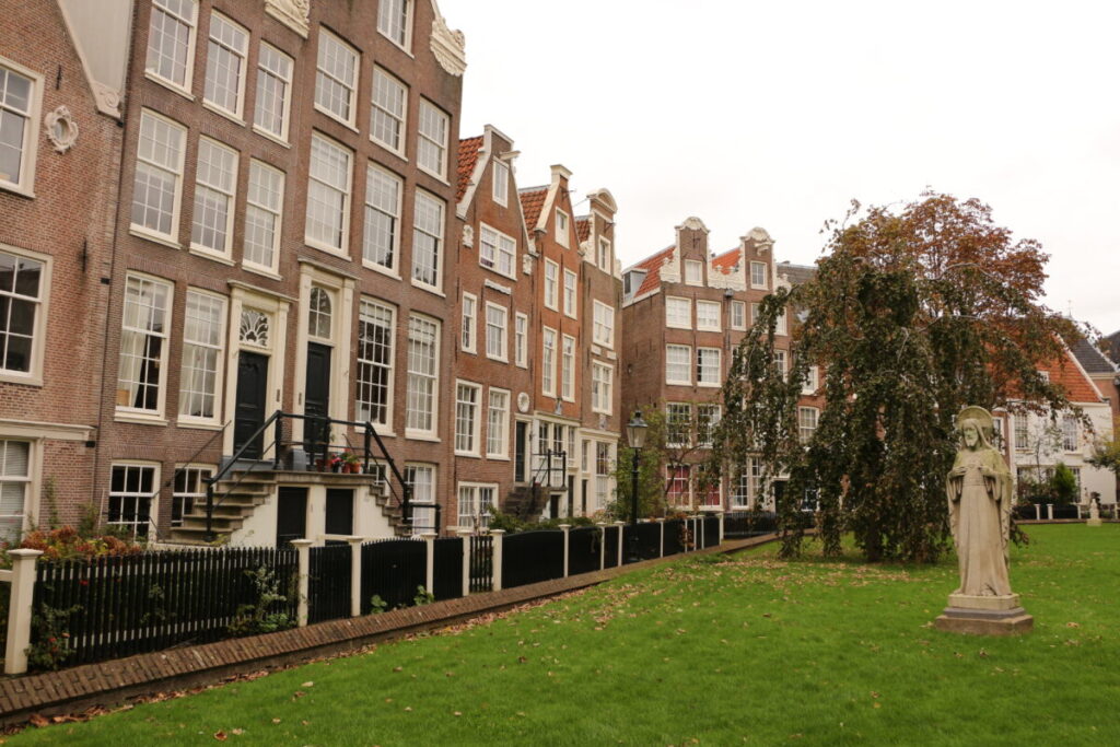 10 Pin‑Drop Perfect Places for Fall Colors in Amsterdam (Exact Spots, Zero Guesswork) 15 Begijnhof in Amsterdam, surrounded by autumn foliage, featuring a prominent statue.