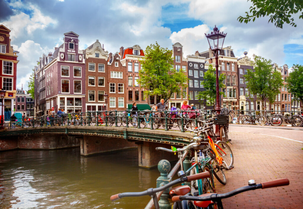 15 Iconic Amsterdam Canals: Explore the UNESCO World Heritage Waterways 28 Row of parked bicycles along the canal, with tourists and locals nearby, in Amsterdam, Netherlands