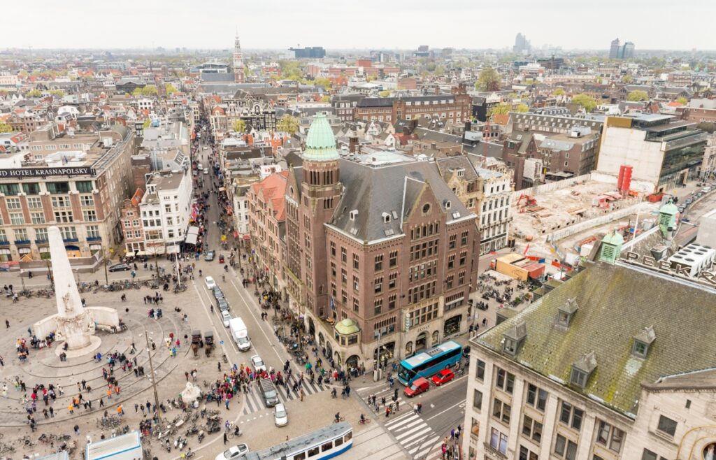 Where to Stay for Amsterdam Dance Event: 2026’s Top Areas & Insider Tips 8 Panoramic view of Dam Square in Amsterdam, featuring historic buildings and bustling crowds under a clear blue sky.