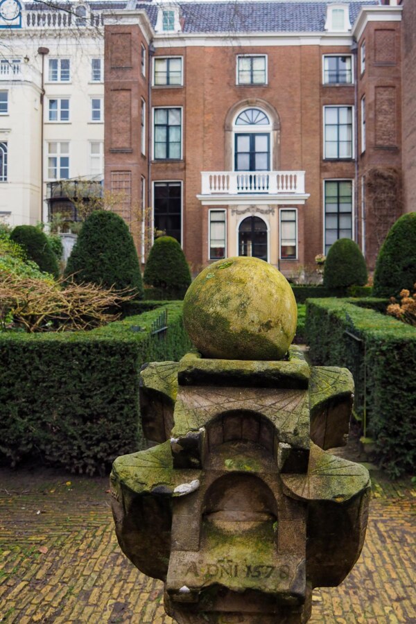 Museum Van Loon 8 Enchanting Sculpture in Museum van Loon, Amsterdam - Antique sculpture with moss-covered sphere, AD 1576 inscription, and canal house mansion in background.