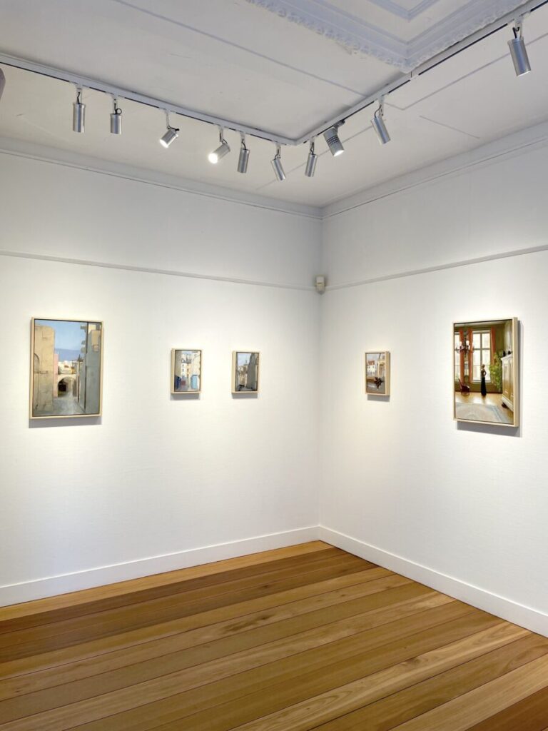How to Find Hidden Hofjes in the Jordaan: Secret Courtyards & Local Tips 24 Galerie Mokum well-lit gallery corner shows five small framed paintings on white walls, each depicting serene interior scenes.
