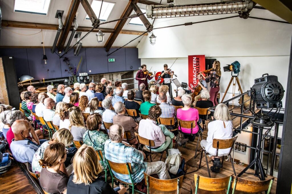 Crowd enjoying a live band at an indoor Grachtenfestival concert in Amsterdam