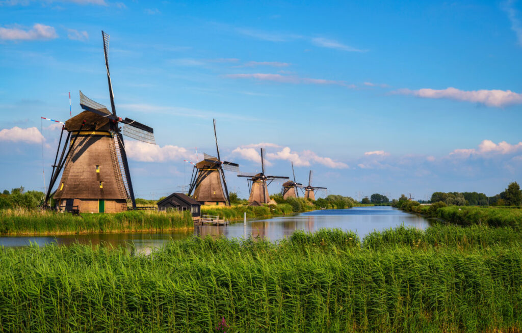 Kinderdijk vs Zaanse Schans Windmills: Which Dutch Icon Wins? 6 Kinderdijk, Netherlands features historic windmills alongside a river, representing the region's rich history and natural beauty.