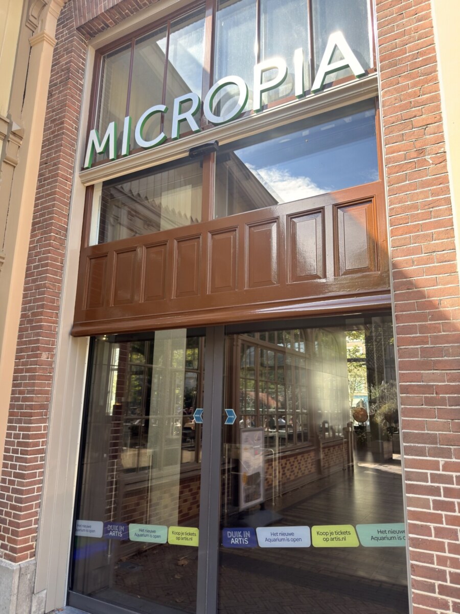 Micropia museum entrance on Artisplein in Amsterdam with red brick facade and glass doors
