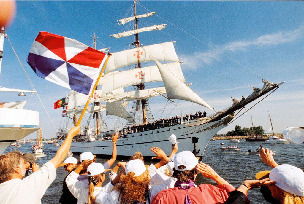 SAIL Amsterdam: 2025 Lookback and When the Next Edition Sails In (2030) 9 People gathered on the water next to the NRP Sagres Tall Ship at the SAIL Amsterdam festival.