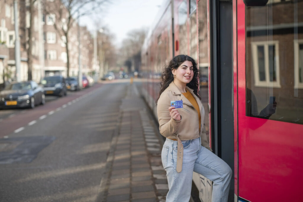 Woman with an OVpay Card entering a tram, ready to use public transportation.
