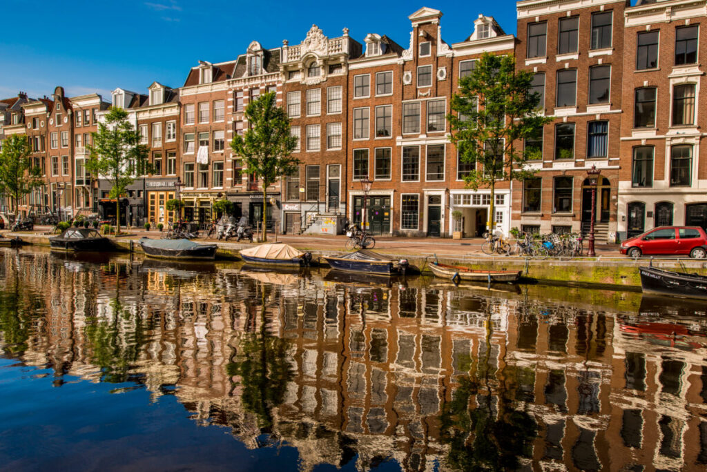Amsterdam Pride 2026: Your Guide to the Canal Parade & Saturday Party Day 5 Scenic view of Prinsengracht Canal in Amsterdam, lined with charming houses and vibrant greenery.
