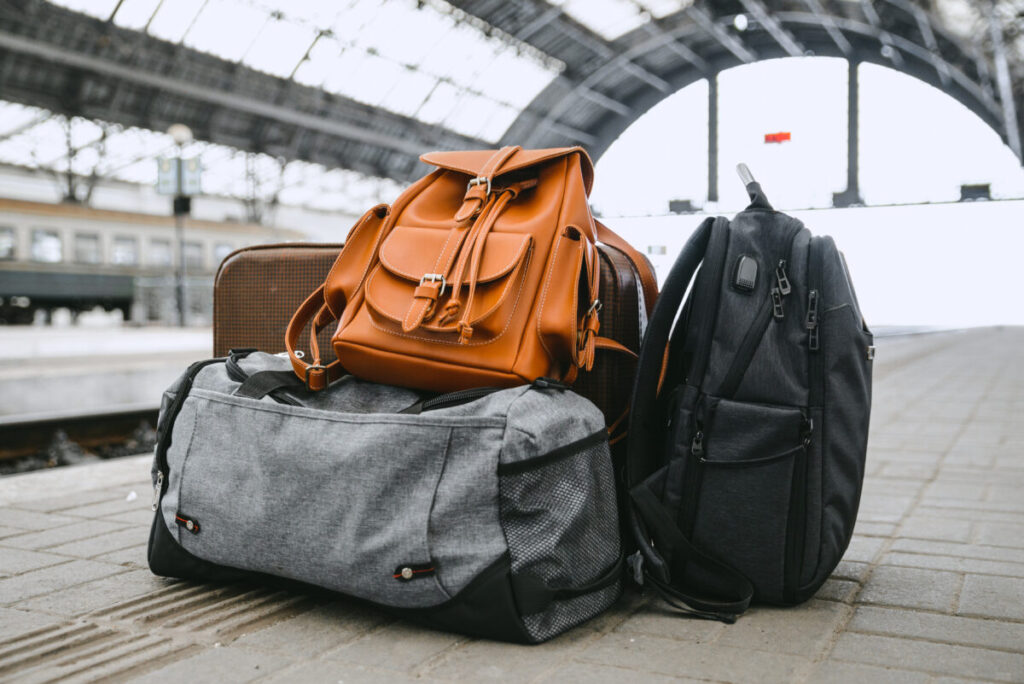 Amsterdam Airport Train vs Taxi: Which Is Better in 2026? 6 Suitcases beside a railway platform in Amsterdam