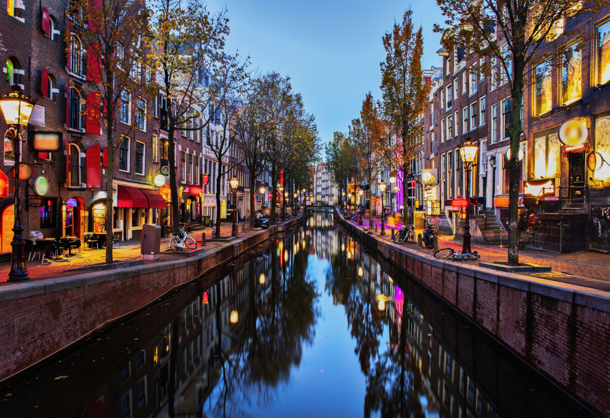 Exploring Amsterdam’s Red Light District: History, Etiquette, and Culture 1 Night lights, canal view, and the establishments of the Red Light District, De Wallen in Amsterdam, Netherlands