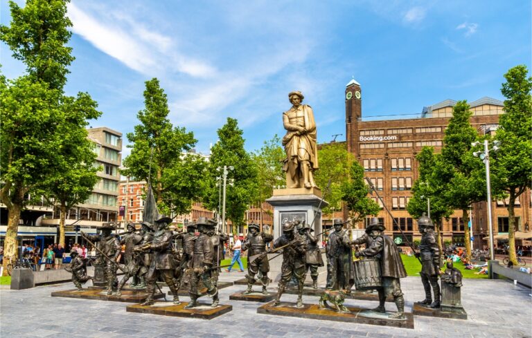 Rembrandt monument and Night Watch sculptures in Rembrandtplein Square, showcasing Amsterdam's artistic heritage