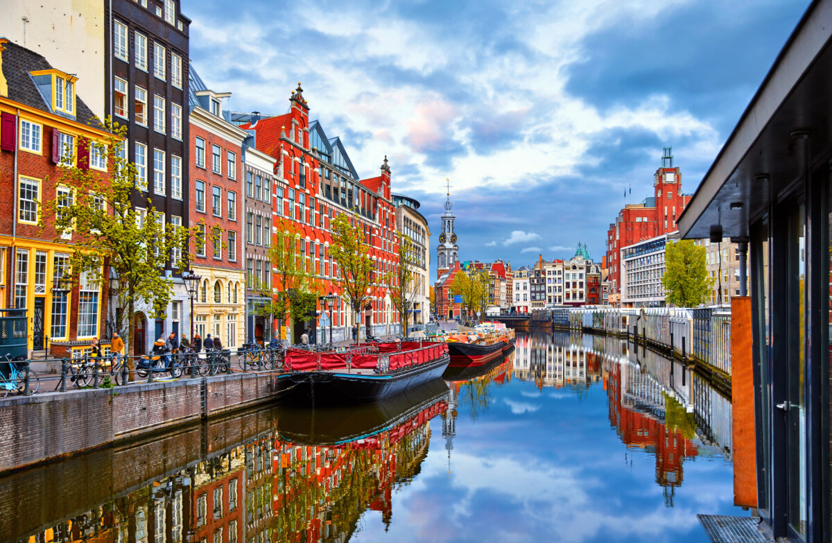 Solo Travel in Amsterdam: A Guide to Exploring the City Alone 1 Panoramic view of the colorful houses by the river Amstel in Amsterdam, Netherlands