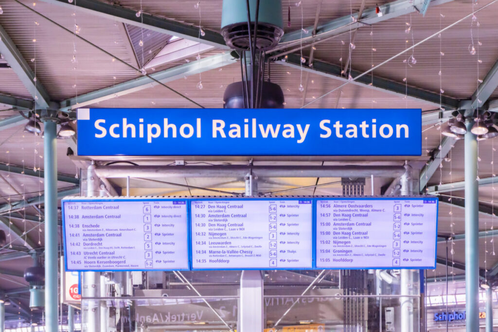 Amsterdam Airport Train vs Taxi: Which Is Better in 2026? 3 Departure boards above the platforms at Schiphol Airport railway station