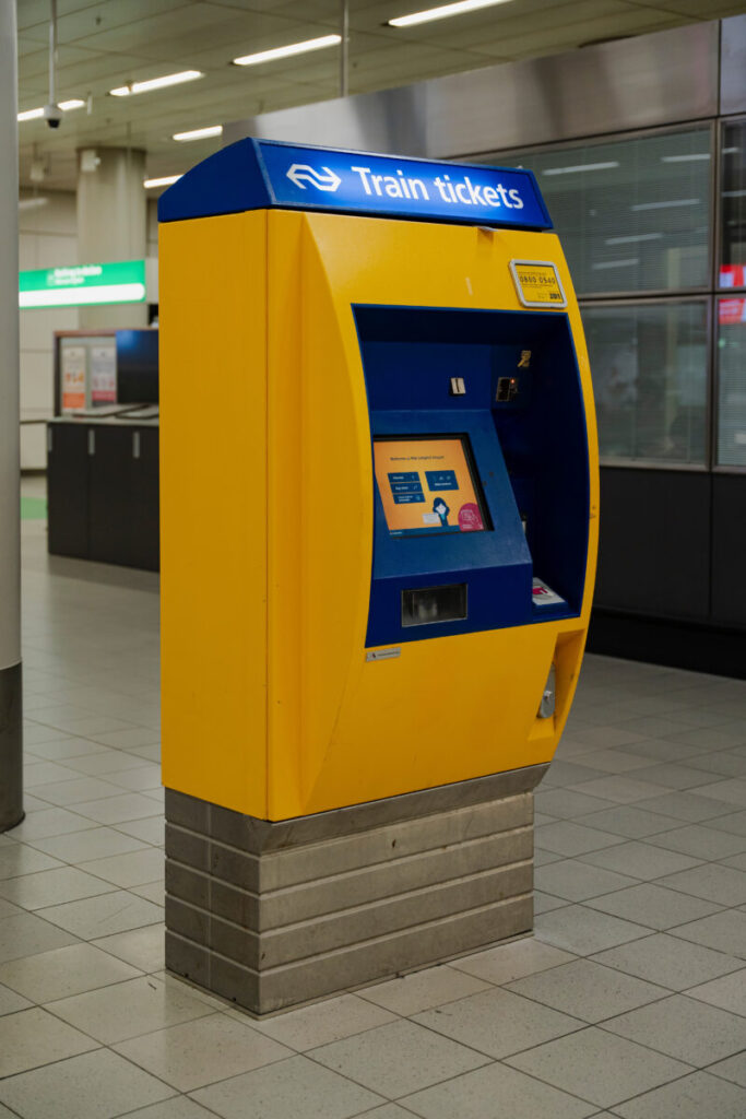 Amsterdam Airport Train vs Taxi: Which Is Better in 2026? 5 Yellow NS ticket machine inside Schiphol Airport station