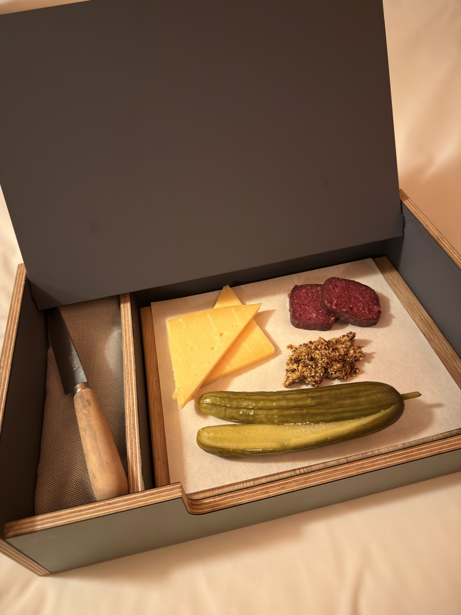 Vuurtoreneiland 23 Custom wooden box containing Dutch artisan cheese, smoked sausage, grain mustard, and pickles with an Opinel knife