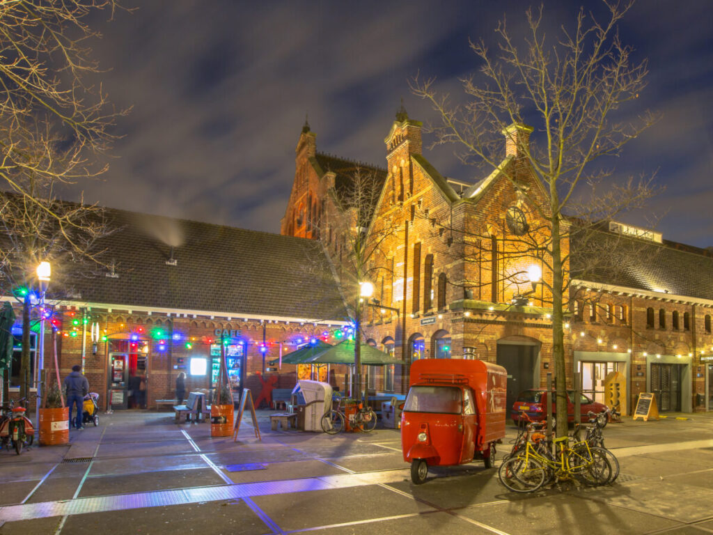 Where to Stay for Amsterdam Dance Event: 2026’s Top Areas & Insider Tips 19 Westerpark in Amsterdam illuminated at night, showcasing vibrant lights and lively atmosphere among trees and pathways.