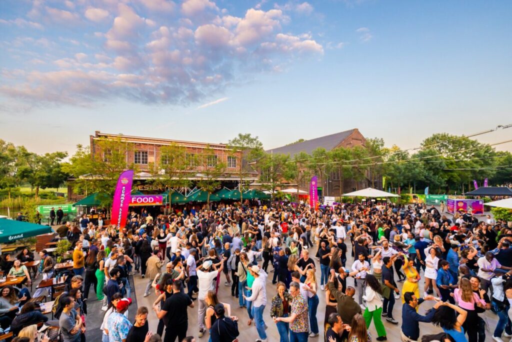 Where to Stay for Amsterdam Dance Event: 2026’s Top Areas & Insider Tips 3 Attendees enjoy an outdoor event at Westerunie, surrounded by greenery in Westerpark, Amsterdam, Netherlands.