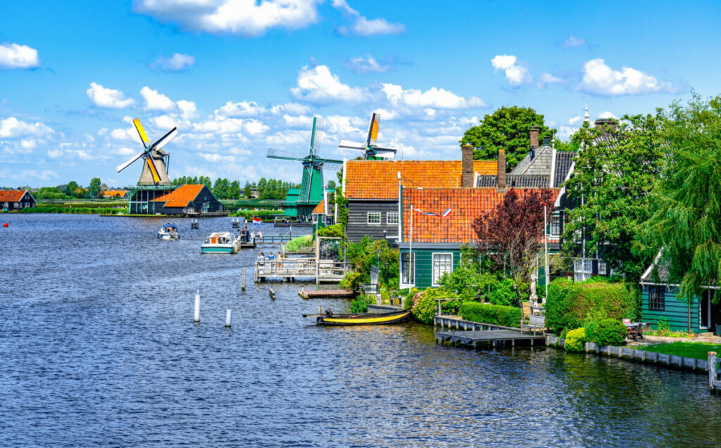 Kinderdijk vs Zaanse Schans Windmills: Which Dutch Icon Wins? 18 Open-air museum Zaanse Schans features traditional wooden buildings, barns, shops, and operational windmills in a picturesque landscape.