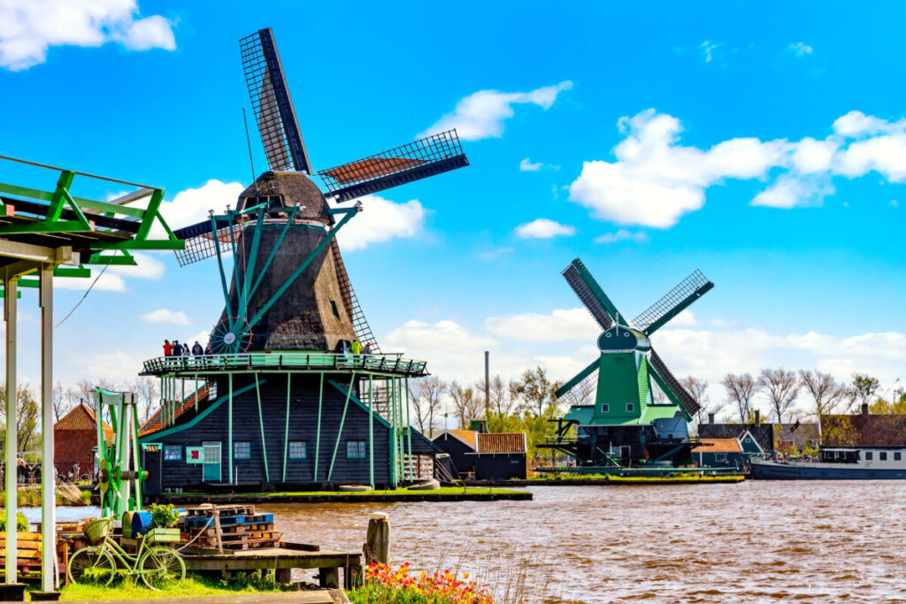 Kinderdijk vs Zaanse Schans Windmills: Which Dutch Icon Wins? 20 Traditional windmills and a vintage bicycle in Zaanse Schans, a picturesque village in the Netherlands, a popular tourist spot.