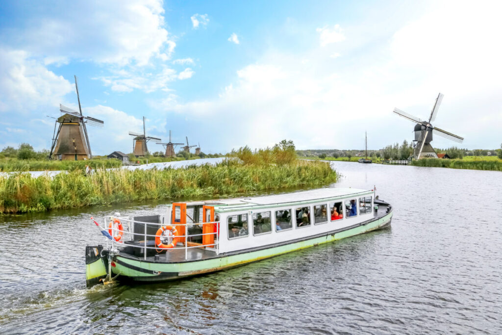Kinderdijk vs Zaanse Schans Windmills: Which Dutch Icon Wins? 21 Scenic boat tour of Zaanse Schans Village, showcasing traditional Dutch windmills and charming canals.
